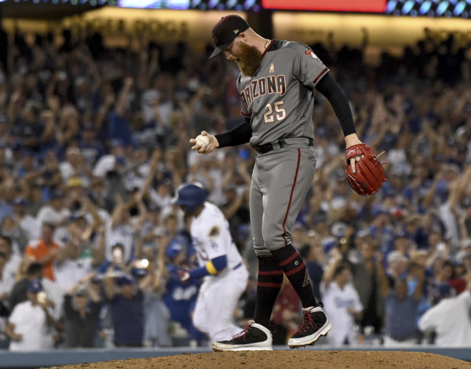 Arizona Diamondbacks pitcher Archie Bradley looks down after giving up a three-run home run to Los Angeles Dodgers' Matt Kemp, rounding the bases, in the eighth inning of a baseball game, Saturday, Sept. 1, 2018, in Los Angeles. (AP Photo/Michael Owen Baker)