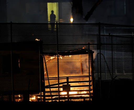 Asylum seekers torched nine buildings at a Sydney detention centre in a night of wild riots with a handful of protesters remaining on rooftops Thursday as police worked to regain control