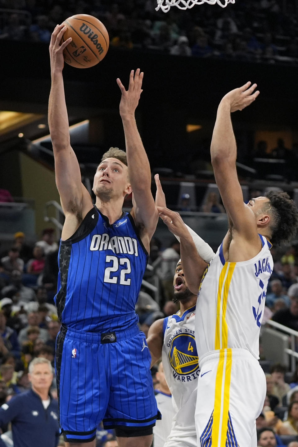 Orlando Magic forward Franz Wagner (22) gets past Golden State Warriors forward Trayce Jackson-Davis for a shot during the first half of an NBA basketball game Wednesday, March 27, 2024, in Orlando, Fla. (AP Photo/John Raoux)