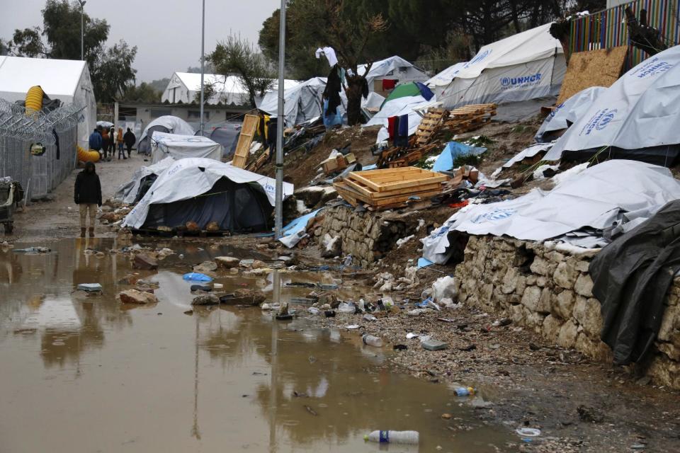 A refugee stands next to a pool of mud at Moria refugee camp on the eastern Greek island of Lesbos, Tuesday, Jan. 10, 2017. Officials said they planned to move some 250 people Tuesday, following strong criticism from aid agencies and medical associations that refugees had been left unprotected during the last heavy snowfall. (Petros Tsakmakis/InTime News via AP)