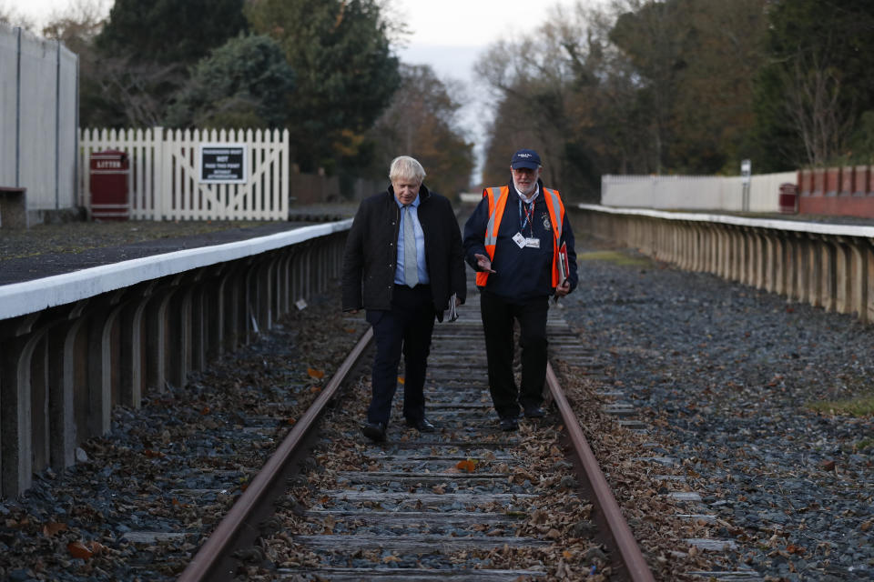 Britain's Prime Minister Boris Johnson, left, and Fleetwood Town councillor Brian Crawford walk during a General Election campaign trail stop at Thornton-Cleveleys railway station, England, Friday, Nov. 15, 2019. Britain goes to the polls on Dec. 12. (AP Photo/Frank Augstein, Pool)