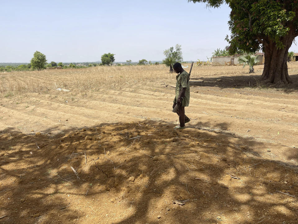 Danjuma Joshua, 36, walks by his two daughters graves in Kunji, Southern Kaduna Nigeria, Thursday , April 27, 2023. Joshua's daughters were shot in the back while they tried to flee when gunman staged a March 2023 late night attack that left 33 dead in the village. (AP Photo/Chinedu Asadu)