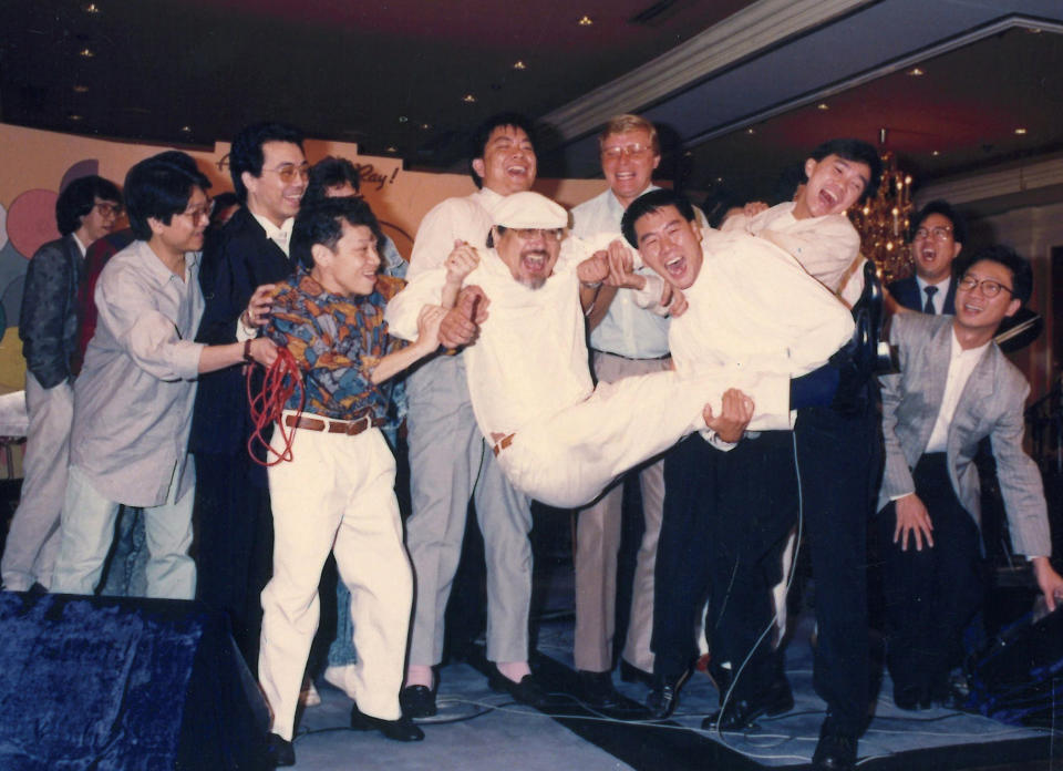 In this undated photo released by Radio Television Hong Kong (RTHK), Hong Kong DJ, Ray Cordeiro, also known as Uncle Ray, center, attends a celebration party after being awarded the Member of the Order of the British Empire in 1987 in Hong Kong. After more than seven decades in radio, the 96-year-old Hong Kong DJ bid farewell to his listeners Saturday, May 15, 2021 with “Time to Say Goodbye,” sung by Sarah Brightman and Andrea Bocelli. (Radio Television Hong Kong via AP)