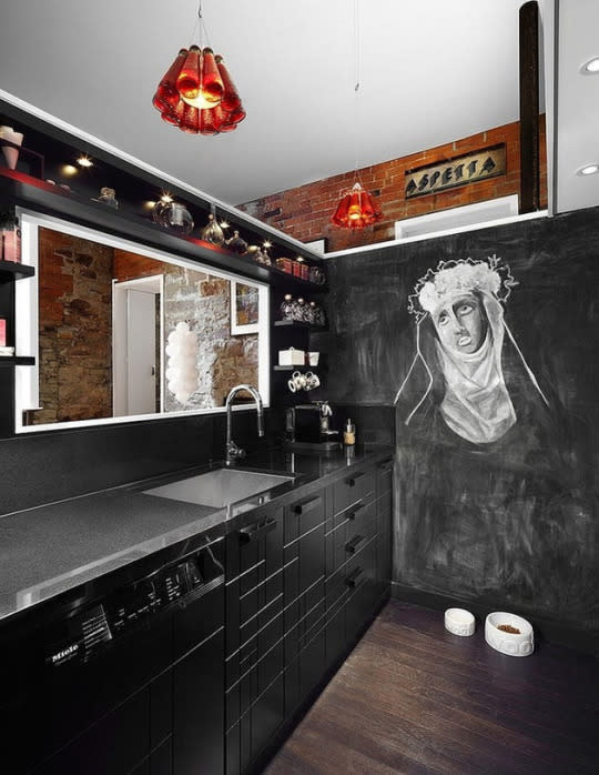 A chalkboard wall makes this stark black kitchen ultrahip.