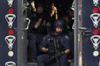 Members of the St. Louis Police Department SWAT team stage near the scene of a shooting Saturday, Aug. 29, 2020, in St. Louis. The St. Louis Police Department says two of their officers have been shot and a suspect is believed to be barricaded in a house nearby. (AP Photo/Jeff Roberson)