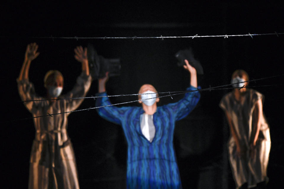 Actresses of the Jewish State Theatre, wearing face masks for protection against COVID-19 infection, perform during the rehearsals for the premiere of the "The Beautiful Days of My Youth" play, based on the diary of Romanian Jewish Holocaust survivor Ana Novac, in Bucharest, Thursday, Oct. 15, 2020. The play premiered online and in front of spectators who took up less than a third of the seats because of measures meant to slow the second wave of the coronavirus pandemic in the eastern European nation. (AP Photo/Andreea Alexandru)