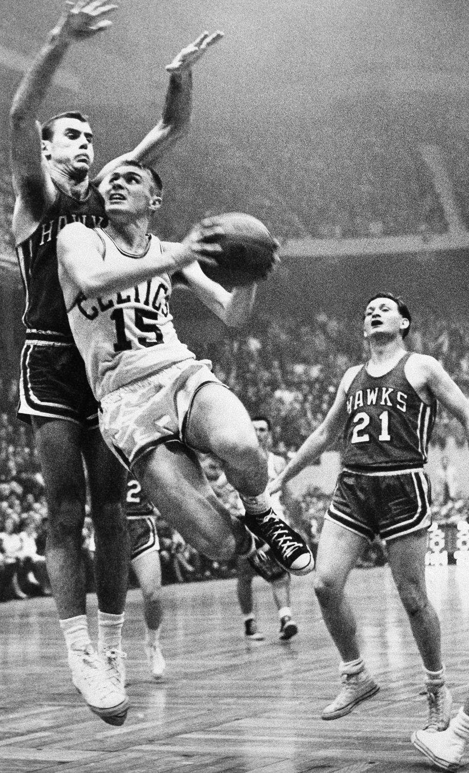 Tommy Heinsohn, (15) of the Boston Celtics leaps to score as Bob Pettit, left, of the <a class="link " href="https://sports.yahoo.com/nba/teams/atlanta/" data-i13n="sec:content-canvas;subsec:anchor_text;elm:context_link" data-ylk="slk:St. Louis Hawks;sec:content-canvas;subsec:anchor_text;elm:context_link;itc:0">St. Louis Hawks</a> attempts to block the play in their National Basketball Association playoff game at Boston Garden on April 10, 1958. Watching the play is Jack McMahon (21) of the Hawks. AP Photo/J. Walter Green