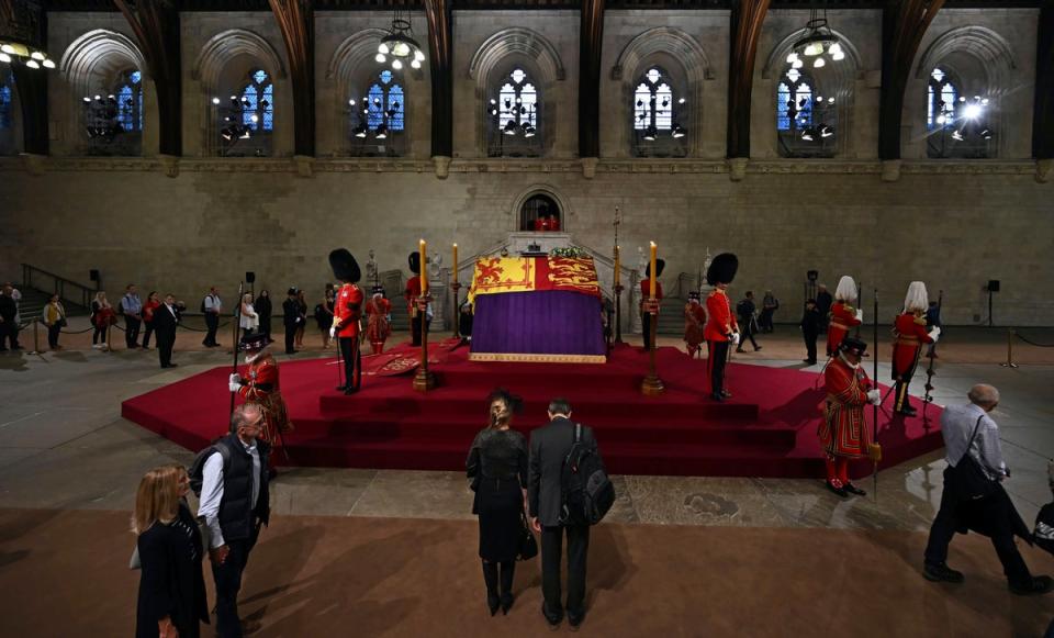 Miembros de la fila del público pasan junto al ataúd de la reina Isabel II (PA)