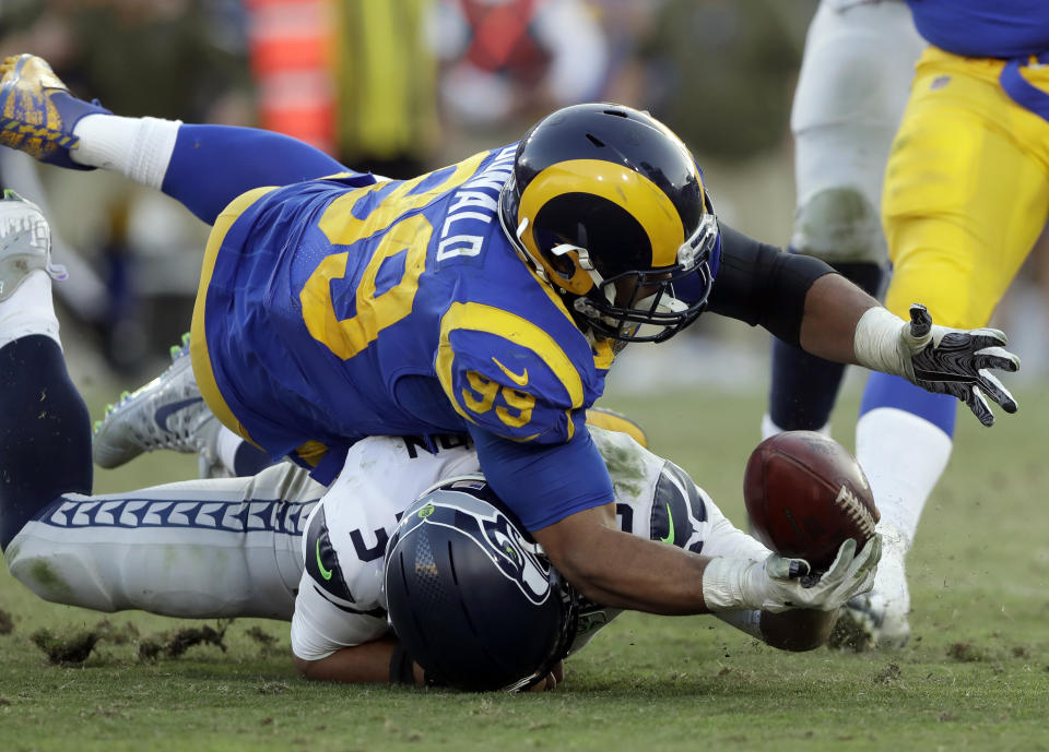 FILE - In this Nov. 11, 2018, file photo, Seattle Seahawks quarterback Russell Wilson (3) battles Los Angeles Rams defensive end Aaron Donald (93) for a ball Wilson lost on a fumble and returned for a touchdown by defensive end Dante Fowler during the second half in an NFL football game in Los Angeles. The Rams know they've got to pressure Tom Brady early and often to have a chance in the Super Bowl, and they've been assembling the tools for this job all year long. They signed Ndamukong Suh to a big free-agent deal, wrote a record-breaking contract for Aaron Donald and acquired edge rusher Dante Fowler from Jacksonville down the stretch. (AP Photo/Alex Gallardo, File)