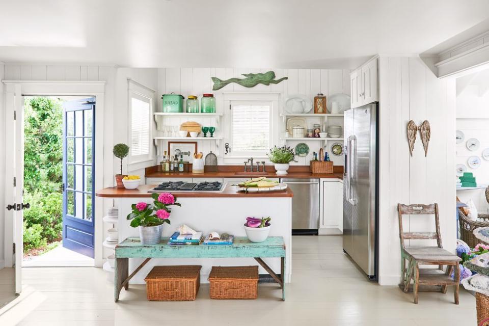 white beach house kitchen with turquoise accents and bright blue painted french door