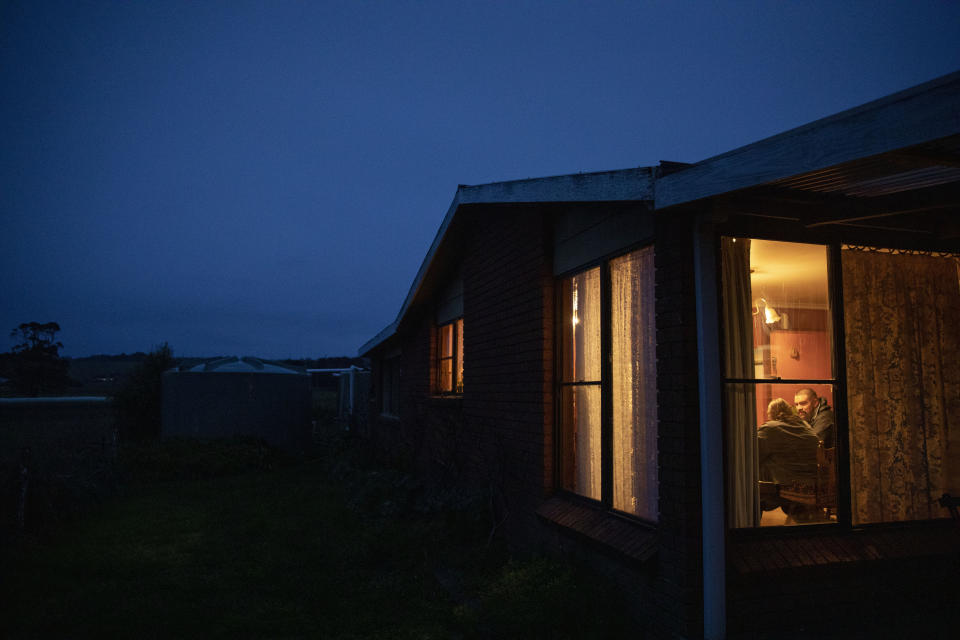 Carmall Casey, left, is visited by Jake Marshall, a friend who has recovered from an opioid addiction himself, at her home in Black River, Tasmania, Australia, Tuesday, July 23, 2019. Here in Tasmania, there are echoes of American Appalachia, in the rural towns, the poverty and the cascade of lives torn apart by pills that promised to take away the pain but in the end created more. (AP Photo/David Goldman)