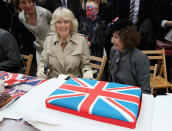 LONDON, ENGLAND - JUNE 03: Camilla, Duchess of Cornwall presents a Union Jack cake she bought as she attends the 'Big Jubilee Lunch' in Piccadilly ahead of the Diamond Jubilee River Pageant on June 3, 2012 in London, England. For only the second time in its history the UK celebrates the Diamond Jubilee of a monarch. Her Majesty Queen Elizabeth II celebrates the 60th anniversary of her ascension to the throne. Thousands of well-wishers from around the world have flocked to London to witness the spectacle of the weekend's celebrations. The Queen along with all members of the royal family will participate in a River Pageant with a flotilla of a 1,000 boats accompanying them down The Thames. (Photo by Chris Jackson - WPA Pool /Getty Images)