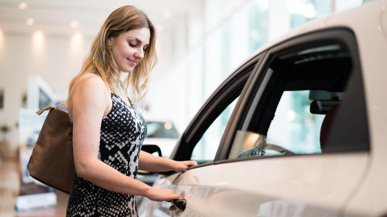 Happy blonde girl looking for her new fancy car.