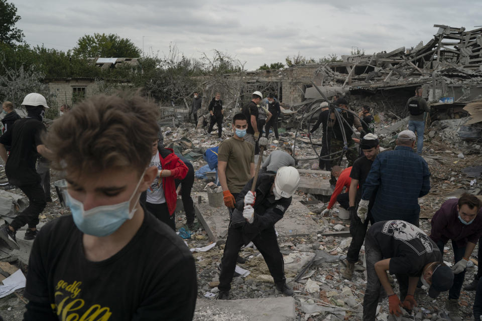 ARCHIVO - Voluntarios trabajando para limpiar escombros en un lugar donde varias casas fueron destruidas por un ataque ruso contra una zona residencial en Zaporiyia, Ucrania, el domingo 9 de octubre 2022. (AP Foto/Leo Correa, Archivo)