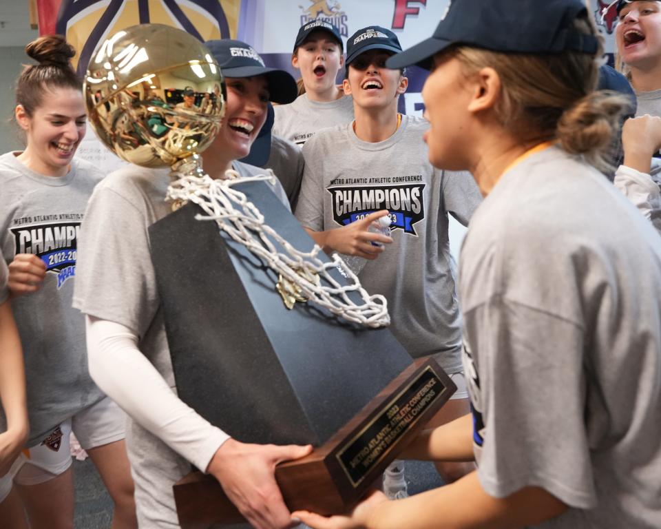 Iona's Juana Camilion celebrates with her teammates and the MAAC Tournament trophy following their win over Manhattan on Saturday, March 11, 2023.