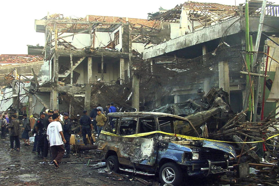 FILE - Police officers inspect the ruins of a nightclub destroyed by a bomb blast in Kuta, Bali, Indonesia, on Oct. 13, 2002. Umar Patek, a bombmaker in the 2002 Bali attacks that killed 202 people, was released from an Indonesian prison on parole Wednesday, Dec. 7, 2022, after serving half his 20-year sentence, despite the opposition of Australia’s prime minister, who described him as “abhorrent.” (AP Photo, File)