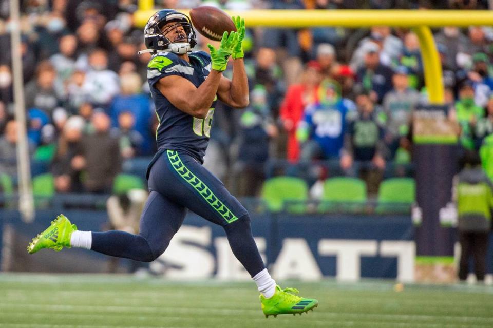 Seattle Seahawks wide receiver Tyler Lockett (16) catches a pass down field from quarterback Russell Wilson (3) during the fourth quarter of an NFL game on Sunday afternoon at Lumen Field in Seattle.