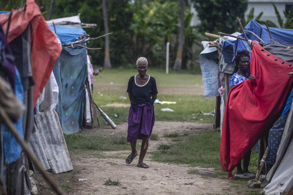 A resident walks through Camp Masse set up by people left homeless by last year’s 7.2-magnitude earthquake, in Les Cayes, Haiti, Wednesday, Aug. 17, 2022. Residents have complained that no government official had visited them despite repeated promises that they would come to help. (AP Photo/Odelyn Joseph)