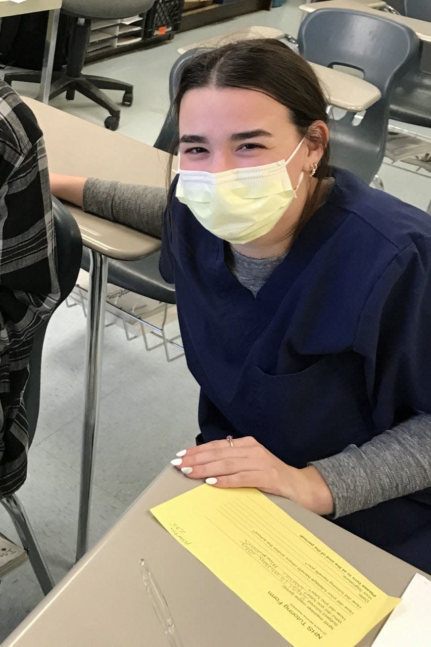 Alli Taylor, one of the NHS tutors at the high school, works with a student on school work.