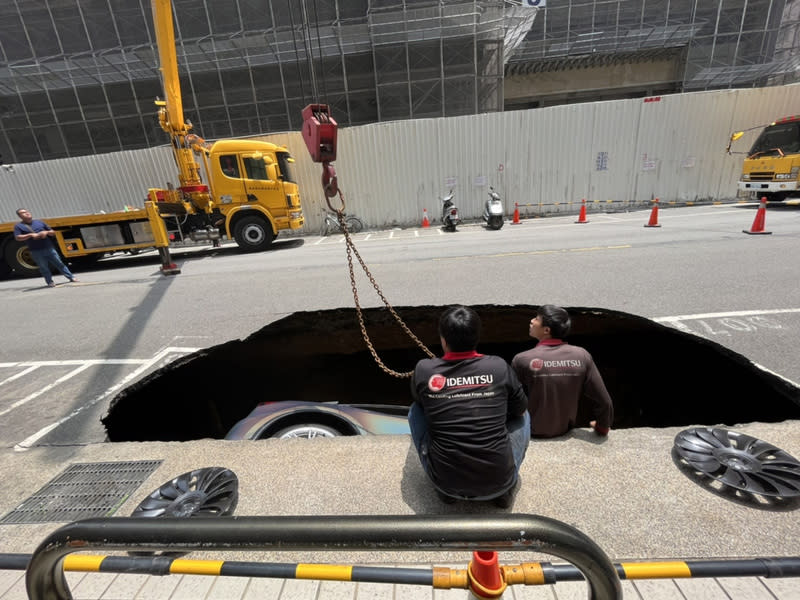 新竹縣竹北市莊敬六街4月27日上午發生路基坍塌，形成一個巨坑，原本停放在停車格內的特斯拉轎車直接掉落，現場出動吊車將車輛吊掛出來。（中央社／新竹縣議員吳旭智提供）