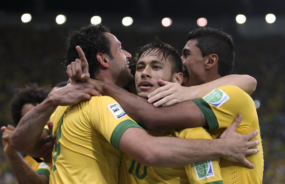 FILE - In this June 30, 2013 file photo, Brazil's Fred, left, celebrates with teammates Neymar, center and Paulinho after scoring his side's 3rd goal against Spain during the soccer Confederations Cup final match at the Maracana stadium in Rio de Janeiro, Brazil. Brazilian fans hoping for a home-team win at thisyear's World Cup are hoping just as hard that archrival Argentina does not lift the trophy.(AP Photo/Andre Penner, File)