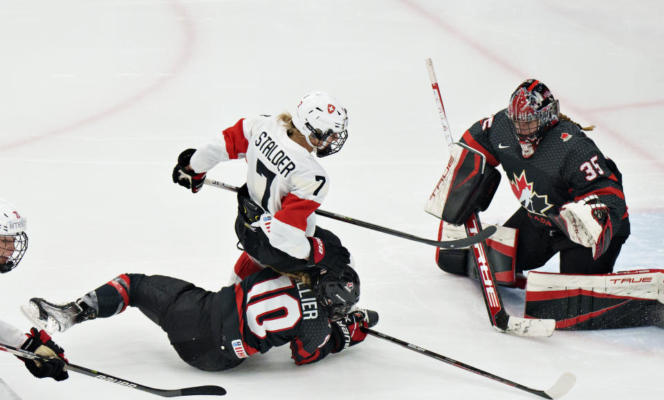 Lara Stalder of Switzerland is sent onto the ice by Sarah Fillier of Canada, during the IIHF World Championship Woman's hockey semi-final match between Canada and Switzerland in Herning, Denmark, Saturday, Sept. 3, 2022. (Henning Bagger/Ritzau Scanpix via AP)