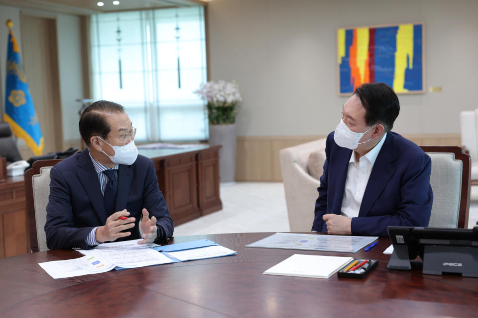 In this photo provided by South Korea Presidential Office, South Korean President Yoon Suk Yeol, right, listens to Unification Ministry's policy briefing by Unification Minister Kwon Youngse at the presidential office in Seoul, South Korea, Friday, July 22, 2022. South Korea plans to lift its decades-long ban on public access to North Korean television, newspapers and other media as part of its efforts to promote mutual understanding between the rivals, officials said Friday, despite animosities over the North's recent missile tests. (South Korea Presidential Office via AP)