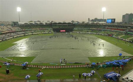 Groundmen cover the field due to rain before the final match of the ICC Twenty20 World Cup between India and Sri Lanka at the Sher-E-Bangla National Cricket Stadium in Dhaka April 6, 2014. REUTERS/Andrew Biraj