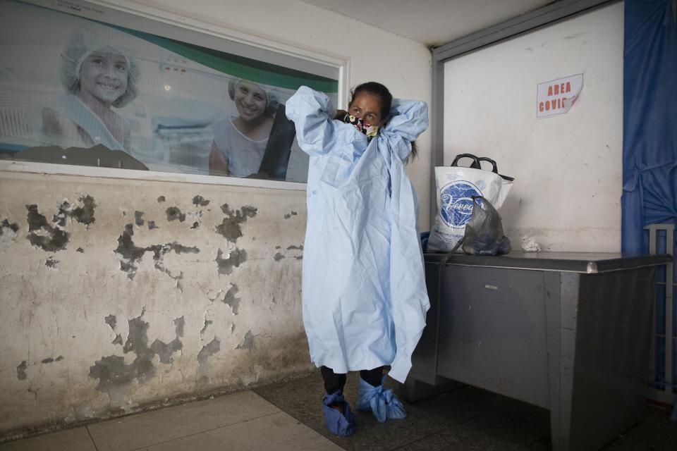 Elena Suazo se prepara para visitar a su padre en la unidad de COVID-19 del hospital José Gregorio Hernández de Caracas el 24 de septiembre del 2020. (AP Photo/Ariana Cubillos)