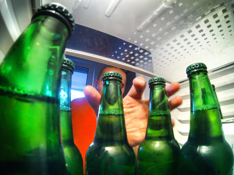 hand reaching into a fridge for some beers