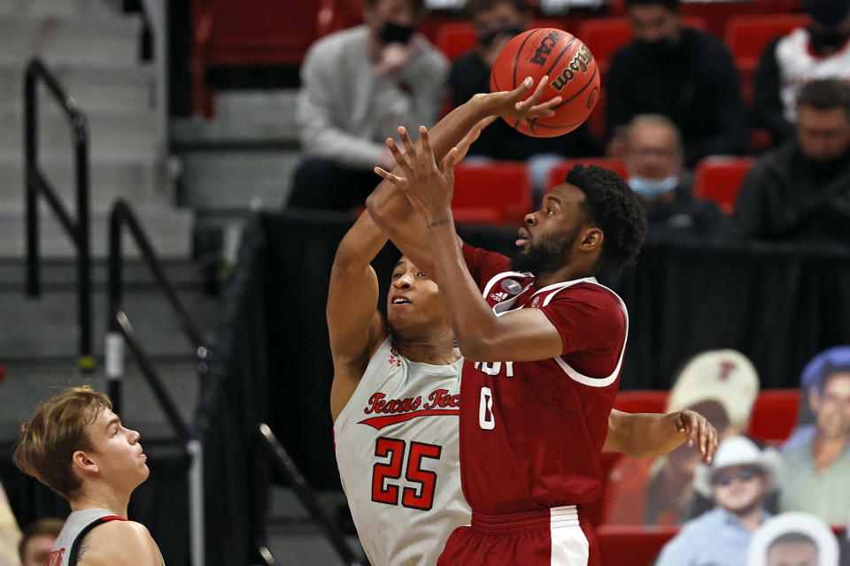 Texas Tech's Nimari Burnett (25) blocks the shot by Troy's Kieffer Punter (0) during the first half of an NCAA college basketball game Friday, Dec. 4, 2020, in Lubbock, Texas. (AP Photo/Brad Tollefson)