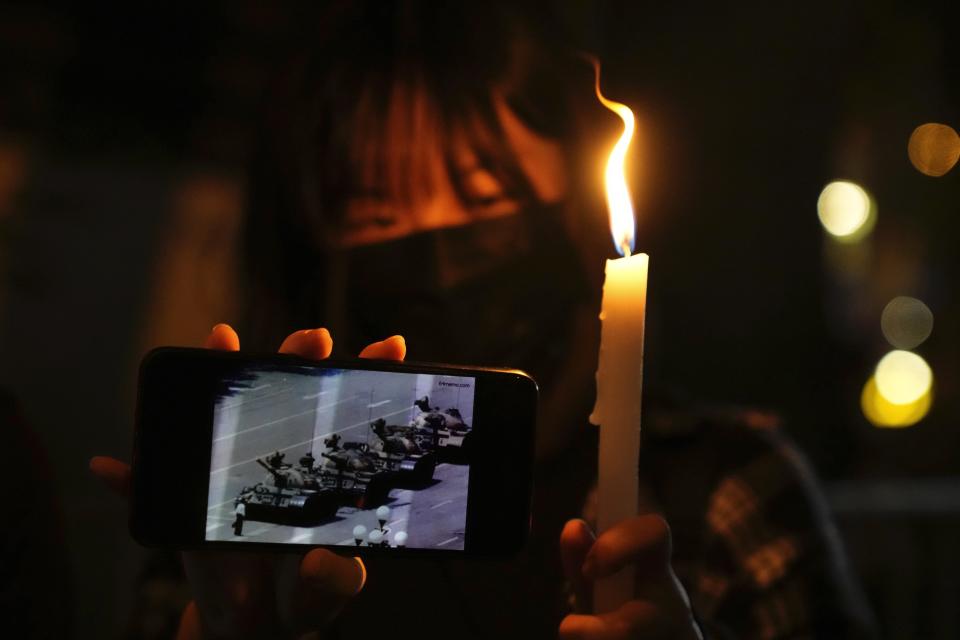 People light candle to mark the anniversary of the military crackdown on a pro-democracy student movement in Beijing, outside Victoria Park in Hong Kong, Friday, June 4, 2021. A member of the committee that organizes Hong Kong's annual candlelight vigil for the victims of the Tiananmen Square crackdown was arrested early Friday on the 32nd anniversary. (AP Photo/Kin Cheung)