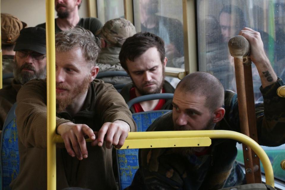 Ukrainian servicemen sit in a bus after they were evacuated from the besieged Mariupol's Azovstal steel plant (AP)