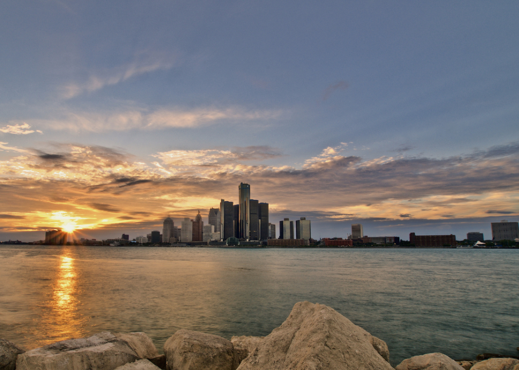 City skyline at sunset with body of water in foreground.