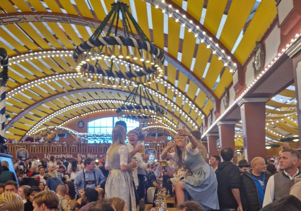 oktoberfest visitors dancing on tables