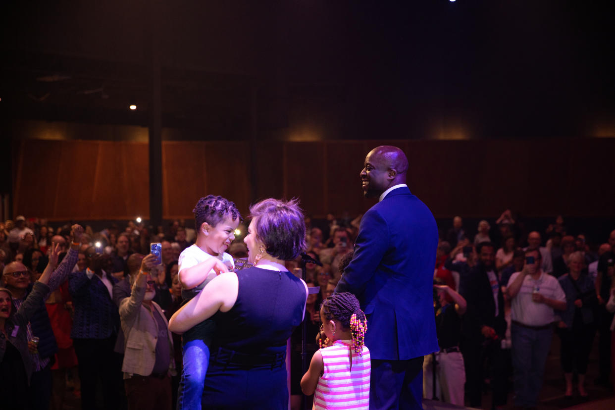 Yemi Mobolade stands on stage with his wife and two of his children.