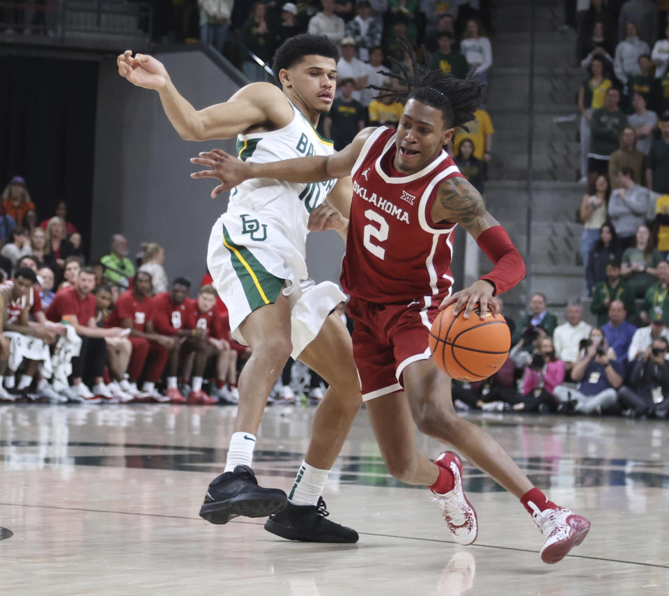 Oklahoma guard Javian McCollum is defended by Baylor guard RayJ Dennis during the first half of an NCAA college basketball game Tuesday, Feb. 13, 2024, in Waco, Texas. (Rod Aydelotte/Waco Tribune-Herald via AP)