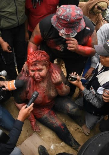 The mayor of the Bolivian town of Vinto, Patricia Arce, speaks to the press as she is being humiliated by a mob of opposition supporters who forcibly cut her hair and covered her in paint
