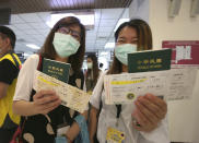 Participants show their boarding pass and passport during a mock trip abroad at Taipei Songshan Airport in Taipei, Taiwan, Tuesday, July 7, 2020. Dozens of would-be travelers acted as passengers in an activity organized by Taiwan’s Civil Aviation Administration to raise awareness of procedures to follow when passing through customs and boarding their plane at Taipei International Airport. (AP Photo/Chiang Ying-ying)