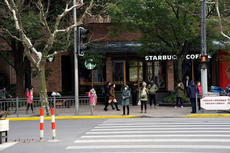 People walk in front of a Starbucks after a vehicle caught fire and mounted the pavement, ploughing into pedestrians in a busy part of central Shanghai, China February 2, 2018. REUTERS/Aly Song