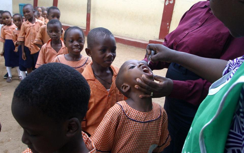 Health workers vaccinate children with drops of polio vaccines in Lagos, Nigeria - GEORGE OSODI/AP