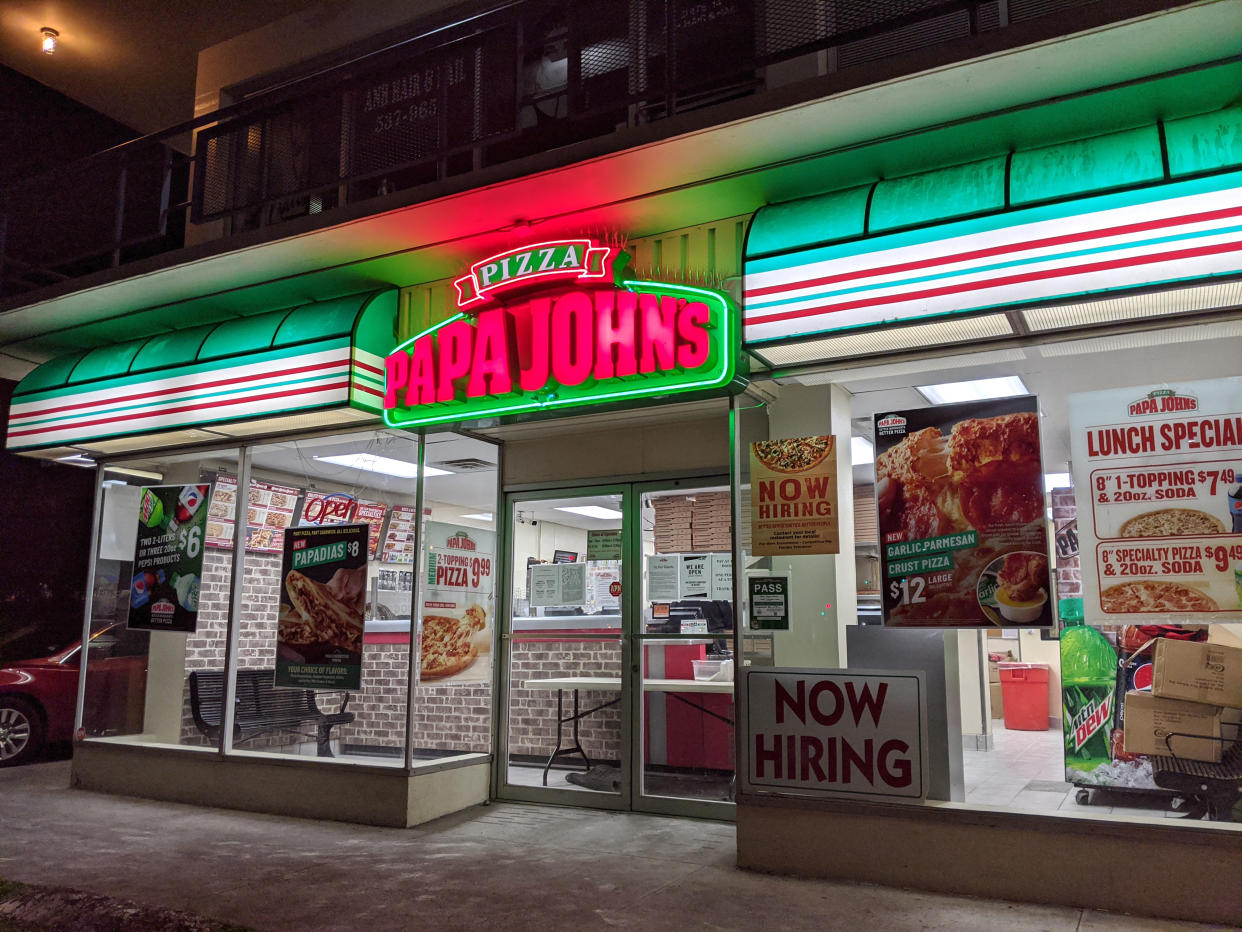 HONOLULU, HI - APRIL 18: Papa John's Pizza store front in Honolulu - April 9, 2020.  Papa John's Pizza entrance at Night.  Papa John's Pizza is an American restaurant company. It runs the third largest take-out and pizza delivery restaurant chain in the world.