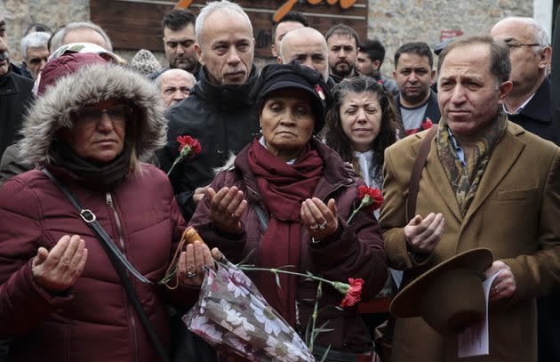 Relatives of terror attack victims who lost their lives after the deadly Islamic State group attack occurred at Istanbul nightclub Reina leave flowers and pray at the site during the commemoration ceremony on Dec. 31, 2017.