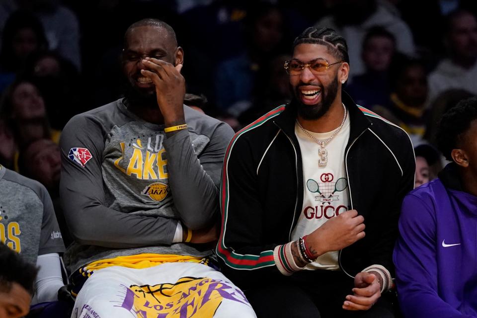 Los Angeles Lakers forward LeBron James, left, and Anthony Davis share a laugh on the sideline during the second half of an NBA basketball game against the Golden State Warriors in Los Angeles, Saturday, March 5, 2022. (AP Photo/Ashley Landis)