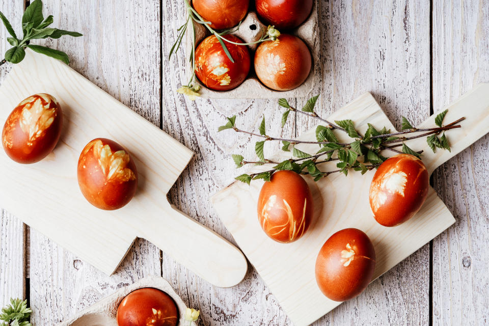 Easter eggs dyed with onion shells and springtime  plants, birch branches viewed from above, zero waste, sustainable living concept, Ukrainian Velykden, local traditions