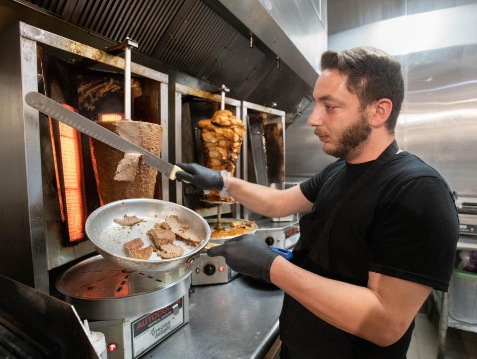 Owner Mohamed Dali slices meat as he prepares a gyro at the new Levant Mediterranean restaurant at 440 East Chase Street in Pensacola on Monday, May 6, 2024.