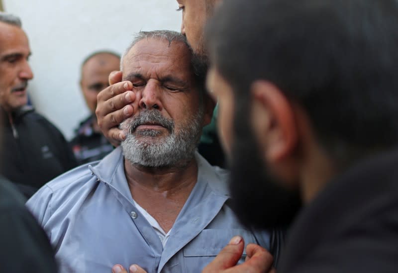 Palestinian man is comforted as he reacts after his relative was killed in Gaza