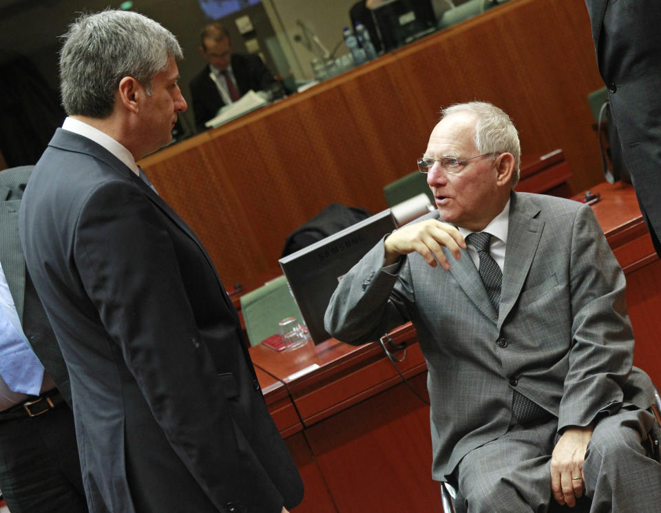 German Finance Minister Wolfgang Schaeuble, right, talks with Austrian Finance Minister Michael Spindelegger, prior to the start of the EU finance ministers meeting at the European Council building in Brussels, Tuesday, Feb. 18, 2014. (AP Photo/Yves Logghe)