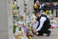 <p>LONDON, UNITED KINGDOM - SEPTEMBER 09: An officer lays flowers in memory of Queen Elizabeth II at Buckingham Palace on September 9, 2022, in London, United Kingdom. London pays tribute and remembers since yesterday, September 8, Queen Elizabeth II, who died at the age of 96. An event that puts an end to an unprecedented reign of more than 70 years and marks the accession to the throne of her firstborn, Prince Charles, 73 years old. Buckingham Palace has announced a period of mourning that will last up to seven days after the monarch's funeral, although it is not yet known when it will take place. They have also confirmed that from today royal gunshots will be fired in Hyde Park and the Tower of London, specifically, one shot for each of the years of life of the queen. (Photo By Elisa Bermudez/Europa Press via Getty Images)</p> 