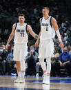 Dallas Mavericks center Kristaps Porzingis (6) gets a pat on the back from Luka Doncic (77) during the first half of the team's NBA basketball game against the Toronto Raptors in Dallas, Wednesday, Jan. 19, 2022. (AP Photo/LM Otero)